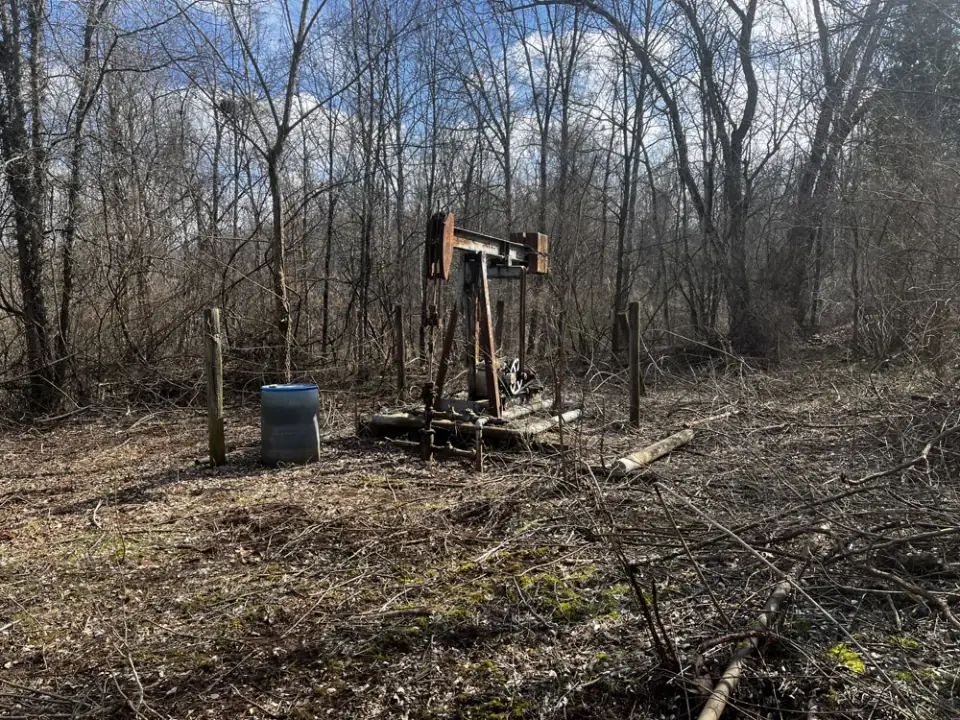 An abandoned pumpjack in winter woodland