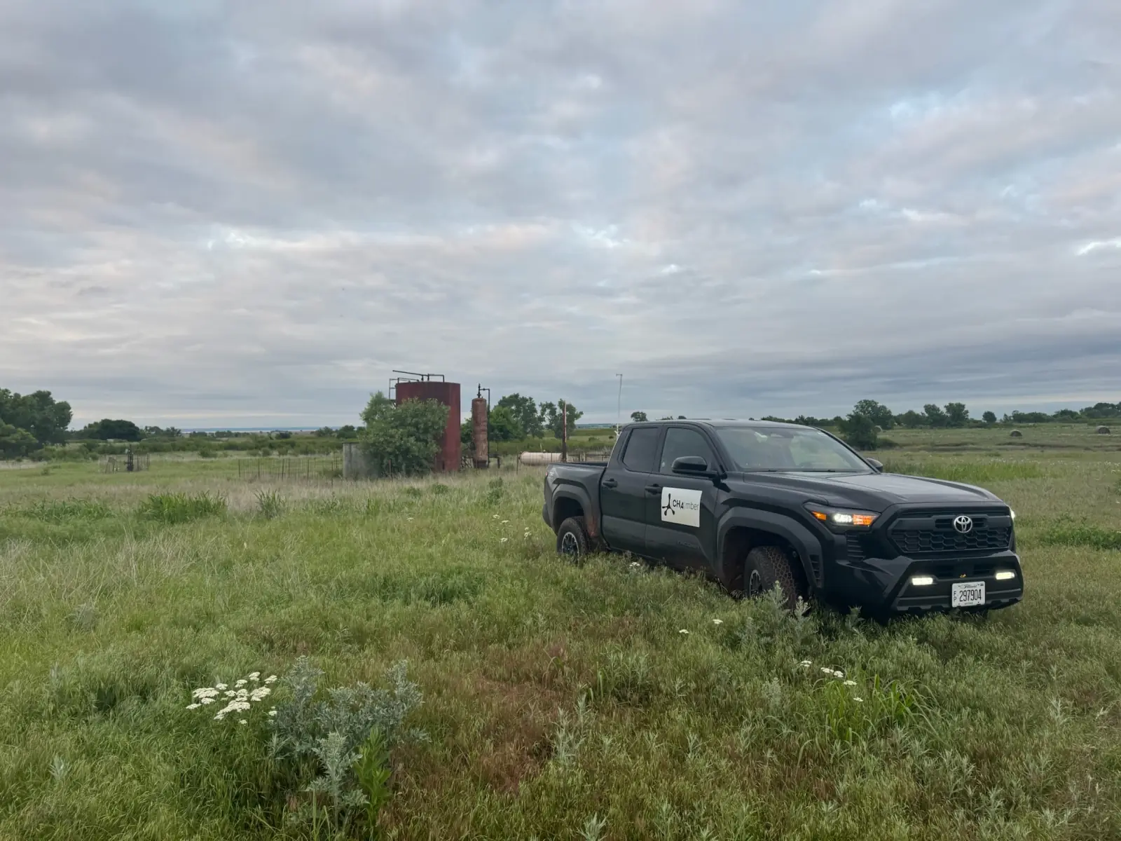 The CH4mber survey truck parked beside a tank battery in pasture